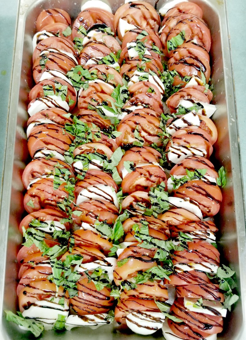 fresh caprese salad with sliced tomatoes, fresh mozzarella, fresh basil, and drizzle of balsamic syrup