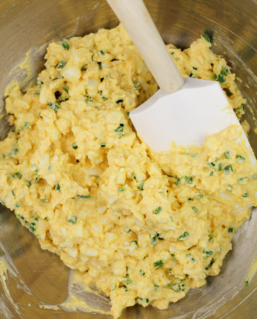 deviled egg salad mixture in bowl with spatula
