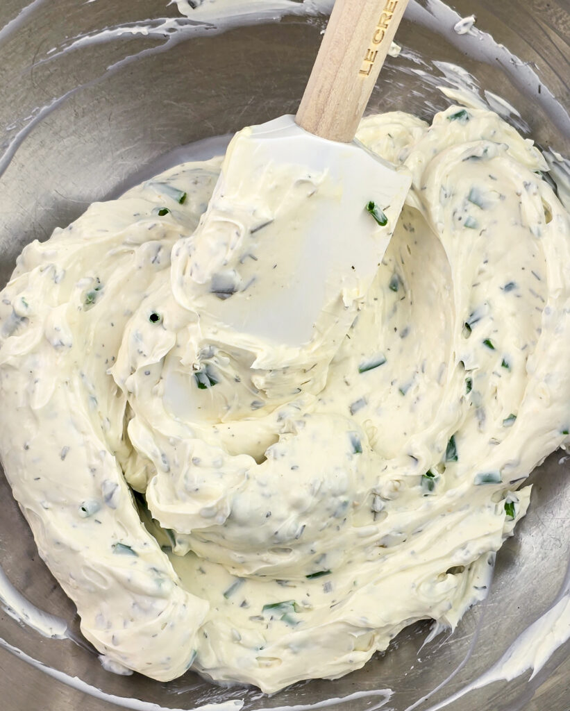 cream cheese filling ingredients combined in metal mixing bowl with rubber spatula