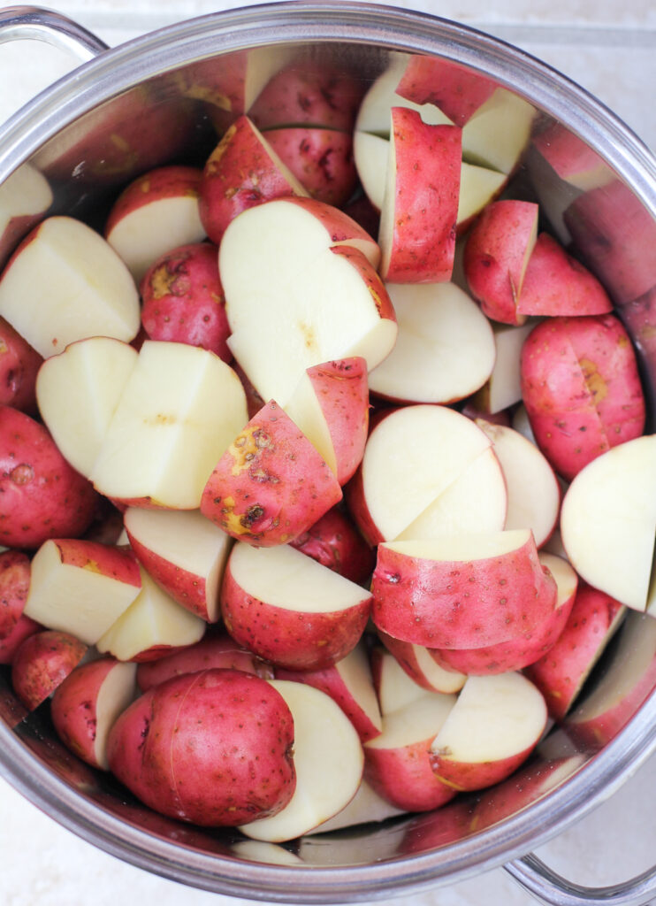 uncooked, cut red potatoes in pot