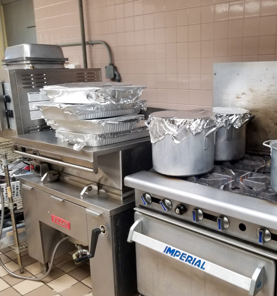 pans covered with foil stacked in industrial kitchen