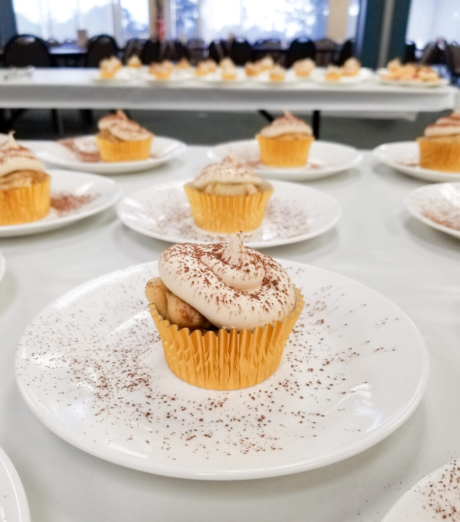 single cupcakes on small white servings dishes laid out on a table