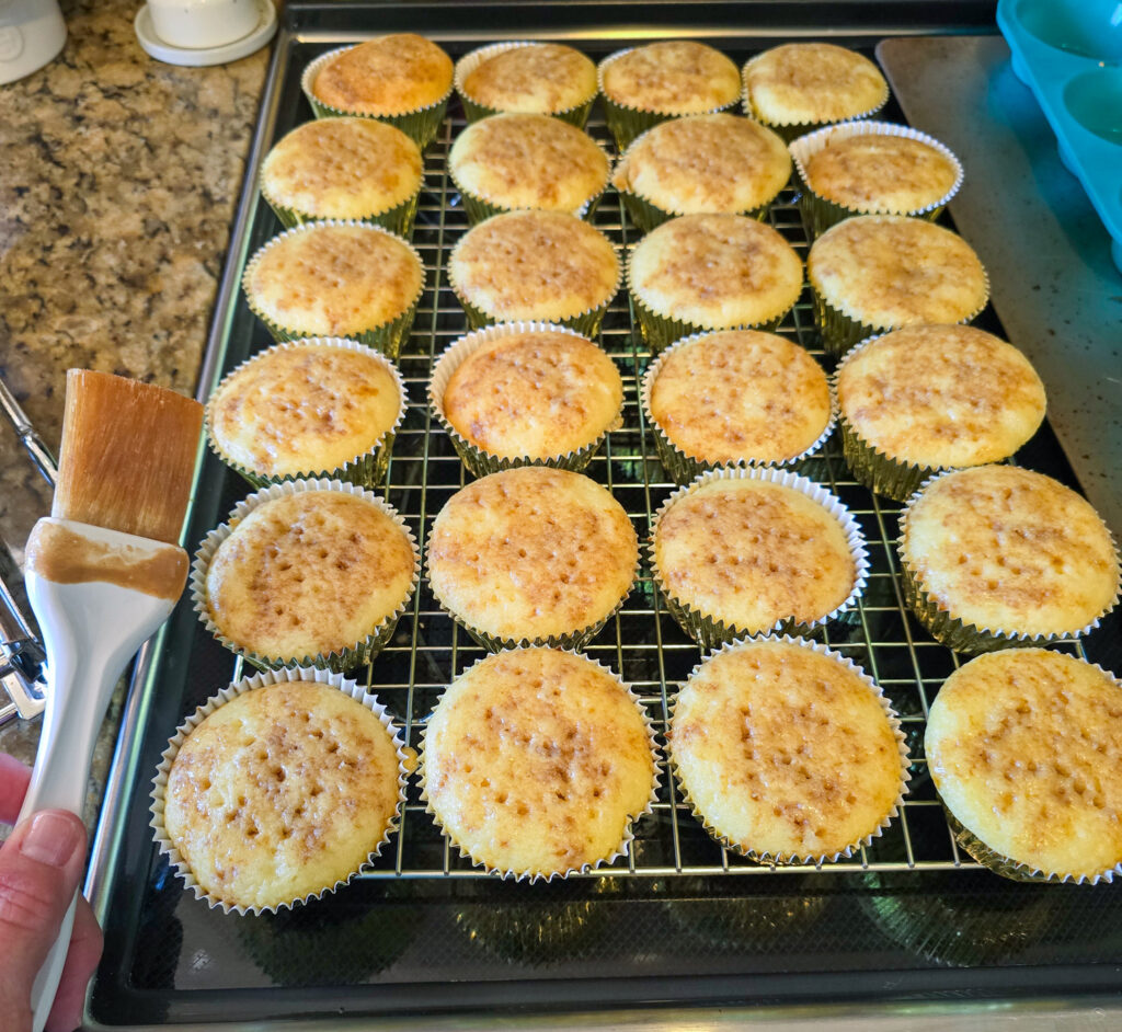 24 cupcakes on wire cooling rack, topped with coffee mixture