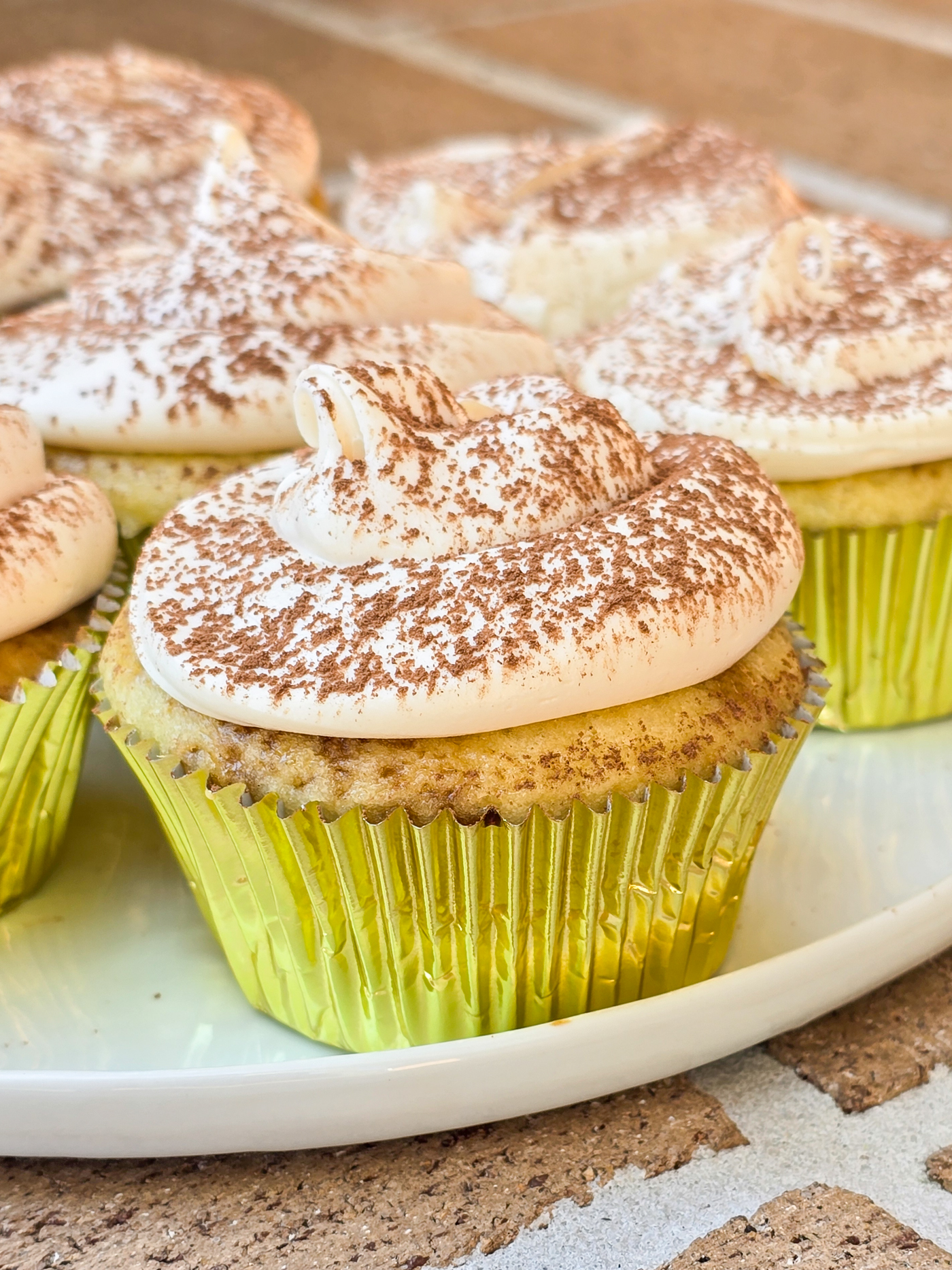 tiramisu cupcakes in gold foil on white plate