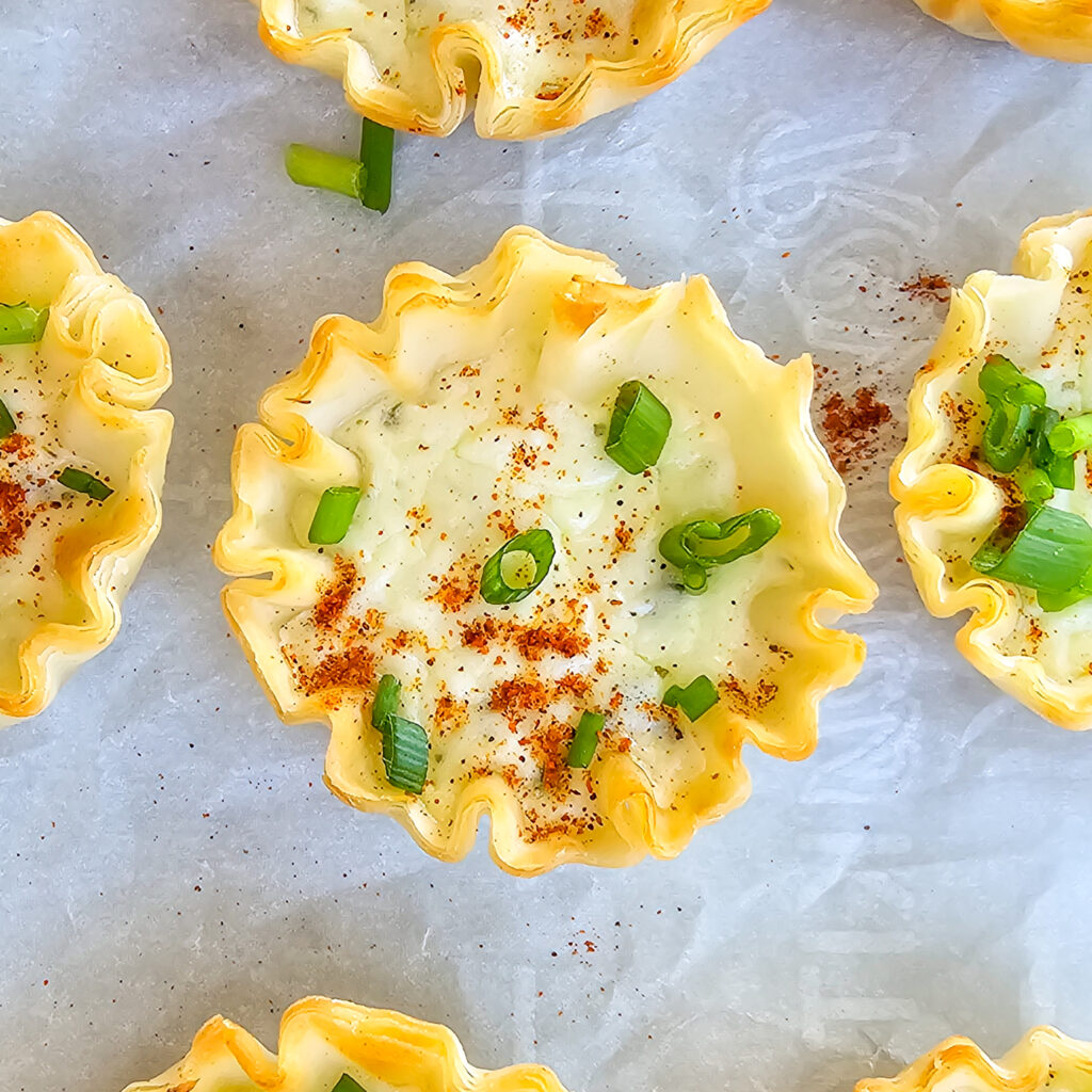 a prepared garlic feta phyllo bite on bake sheet