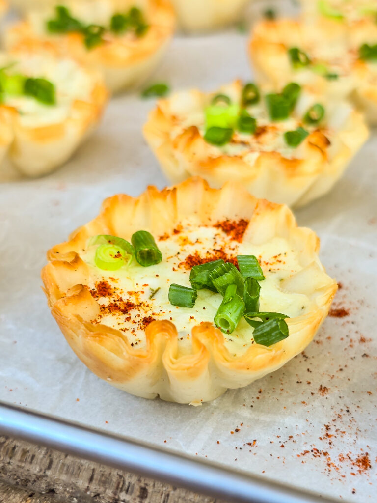 a prepared garlic feta phyllo bite on bake sheet