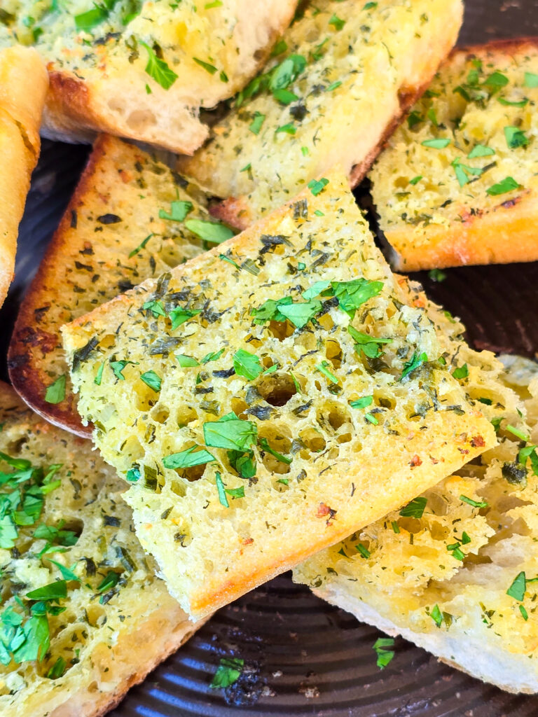 slices of garlic bread on bake sheet