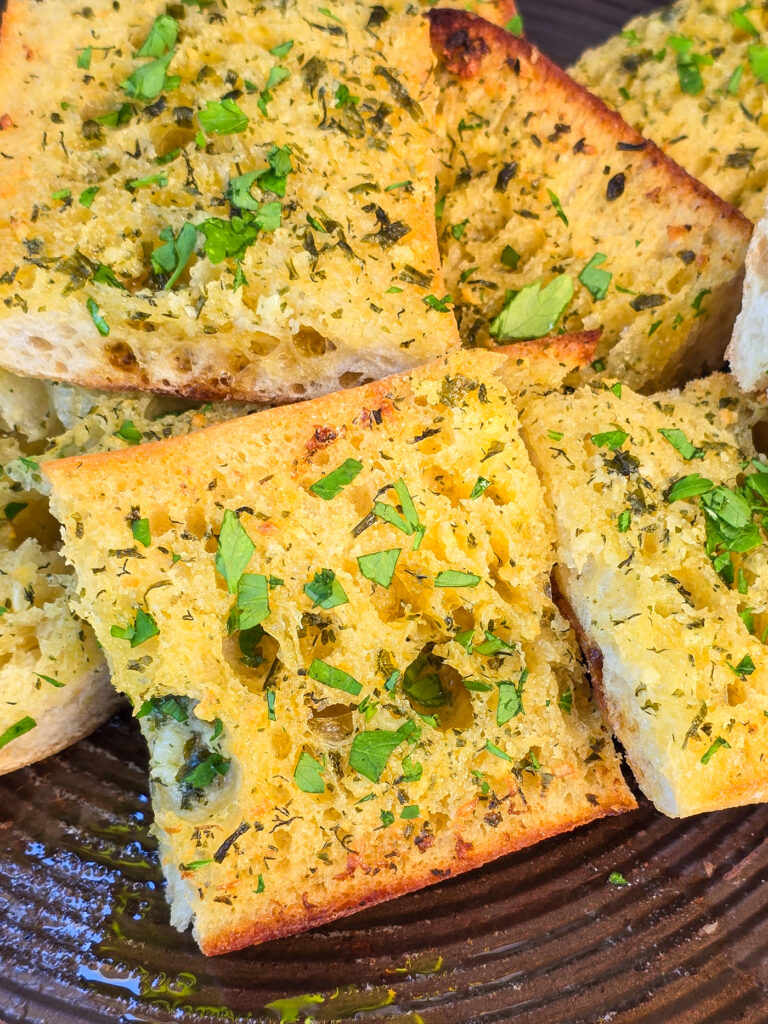 slices of garlic bread on bake sheet