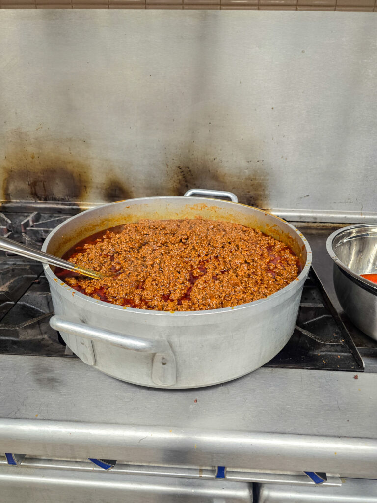 prepared taco meat in large pot on gas burner stove
