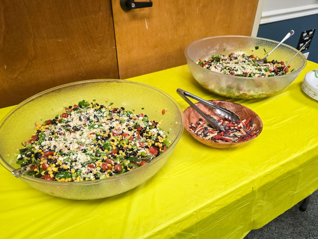 Two large bowls of Southwestern salad with black beans, corn, and cheese alongside tortilla strips on a table